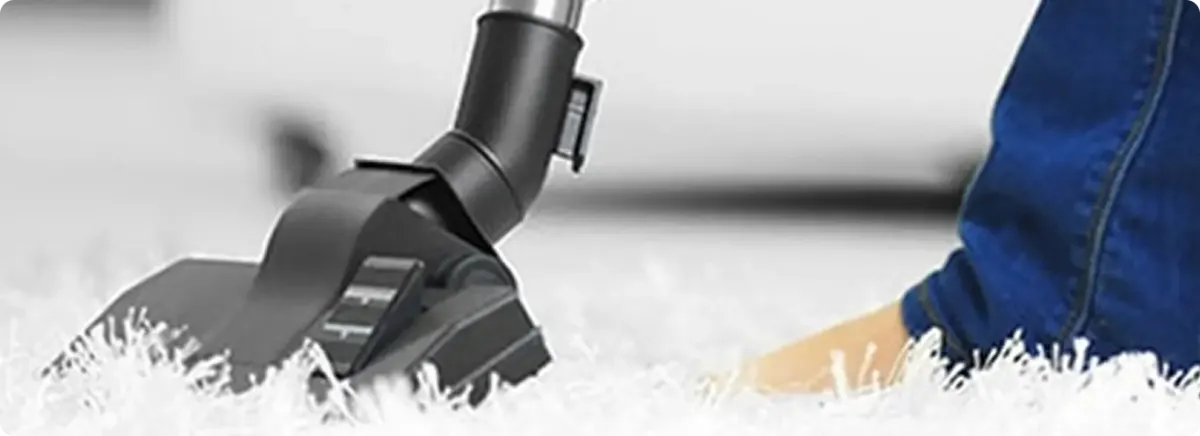 Close-up of a professional vacuuming a white carpet in Willow Beach.
